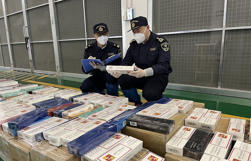 图为：海关关员清点查获的夹藏卷烟+孙忠为摄